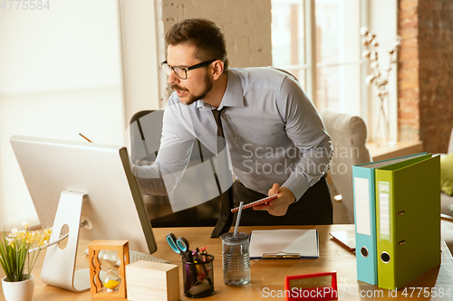 Image of A young businessman moving in office, getting new work place