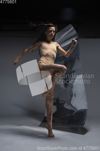 Image of Young and stylish modern ballet dancer on grey background