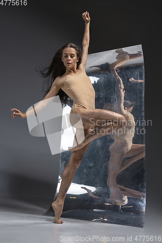 Image of Young and stylish modern ballet dancer on grey background