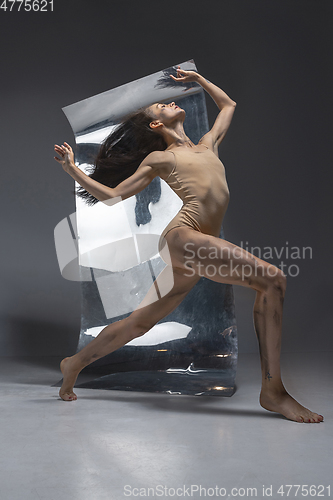 Image of Young and stylish modern ballet dancer on grey background