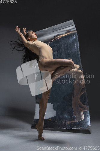 Image of Young and stylish modern ballet dancer on grey background