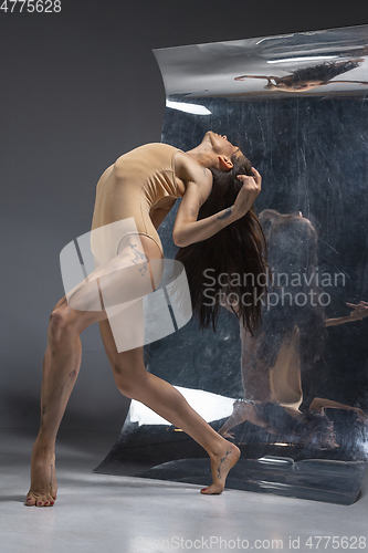 Image of Young and stylish modern ballet dancer on grey background