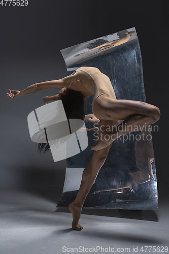 Image of Young and stylish modern ballet dancer on grey background