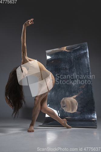 Image of Young and stylish modern ballet dancer on grey background