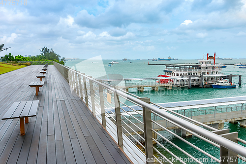 Image of Boardwalk by harbor with ships