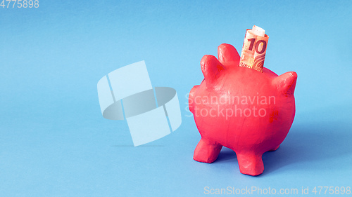 Image of pink papier mache piggy bank with 10 Euros