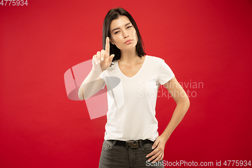 Image of Caucasian young woman\'s half-length portrait on red background