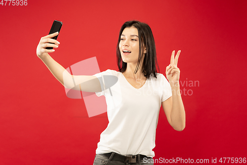 Image of Caucasian young woman\'s half-length portrait on red background