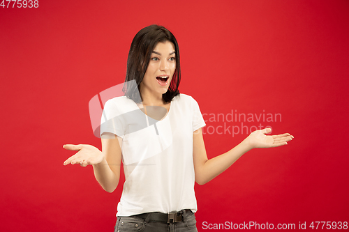 Image of Caucasian young woman\'s half-length portrait on red background