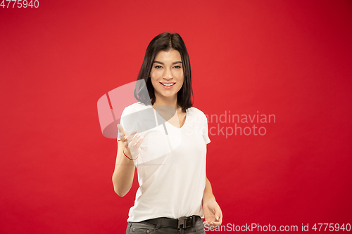 Image of Caucasian young woman\'s half-length portrait on red background