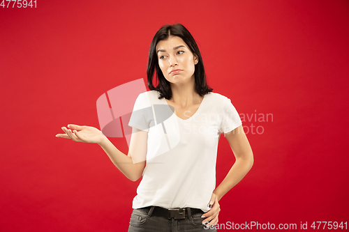 Image of Caucasian young woman\'s half-length portrait on red background