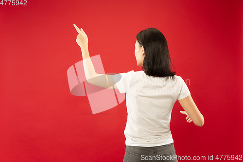 Image of Caucasian young woman\'s half-length portrait on red background