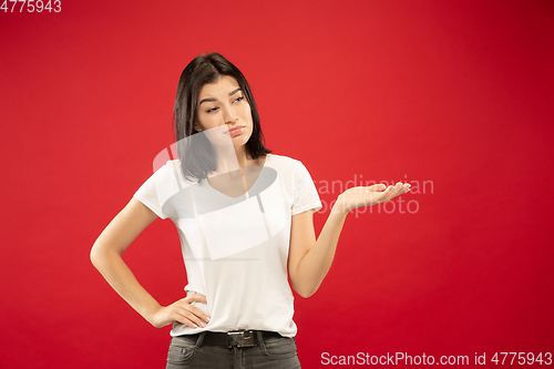 Image of Caucasian young woman\'s half-length portrait on red background