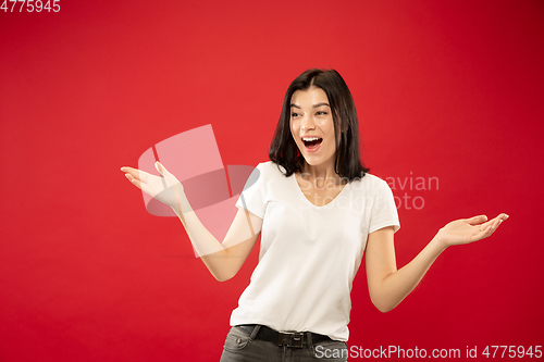 Image of Caucasian young woman\'s half-length portrait on red background