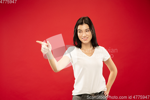 Image of Caucasian young woman\'s half-length portrait on red background
