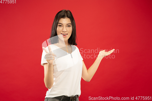 Image of Caucasian young woman\'s half-length portrait on red background