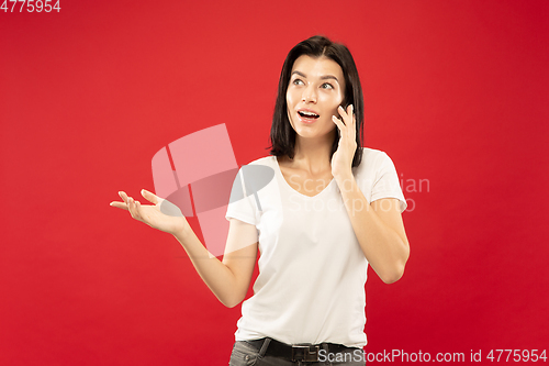 Image of Caucasian young woman\'s half-length portrait on red background