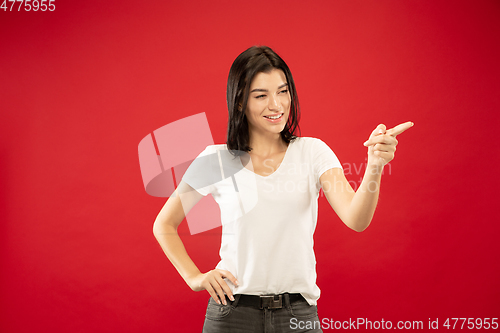 Image of Caucasian young woman\'s half-length portrait on red background