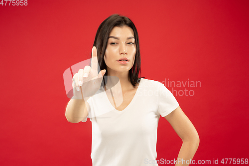 Image of Caucasian young woman\'s half-length portrait on red background