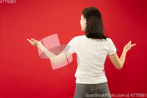 Image of Caucasian young woman\'s half-length portrait on red background