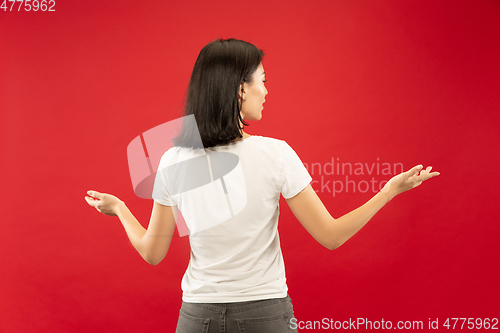 Image of Caucasian young woman\'s half-length portrait on red background