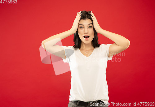 Image of Caucasian young woman\'s half-length portrait on red background