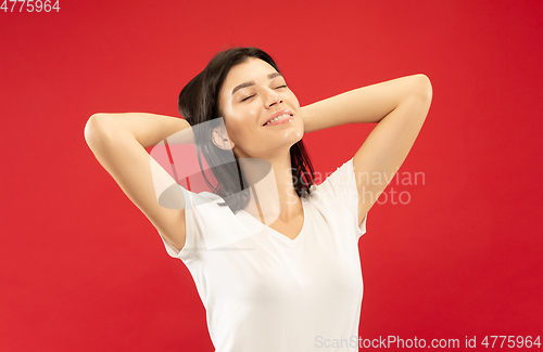 Image of Caucasian young woman\'s half-length portrait on red background
