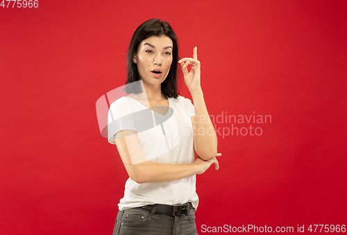 Image of Caucasian young woman\'s half-length portrait on red background