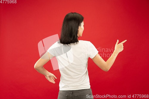 Image of Caucasian young woman\'s half-length portrait on red background
