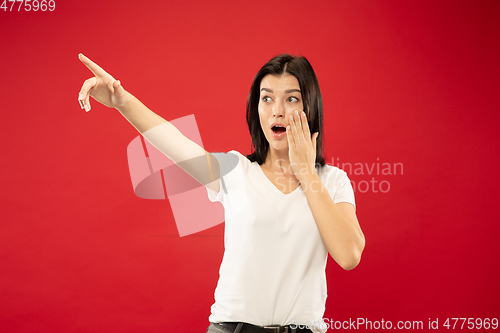 Image of Caucasian young woman\'s half-length portrait on red background