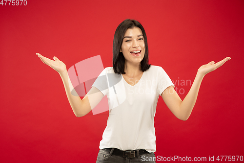 Image of Caucasian young woman\'s half-length portrait on red background
