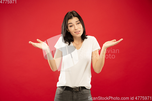 Image of Caucasian young woman\'s half-length portrait on red background