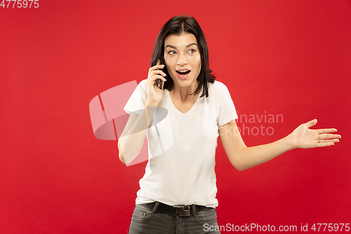 Image of Caucasian young woman\'s half-length portrait on red background