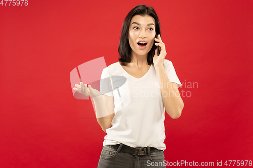 Image of Caucasian young woman\'s half-length portrait on red background