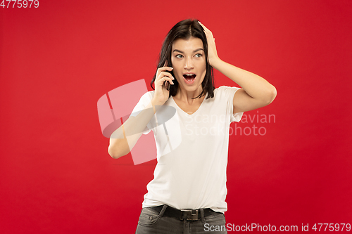 Image of Caucasian young woman\'s half-length portrait on red background