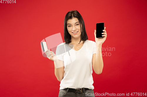 Image of Caucasian young woman\'s half-length portrait on red background