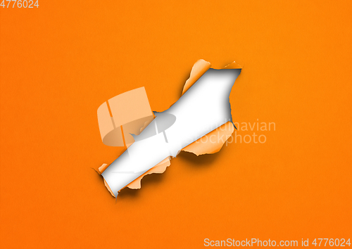 Image of Orange torn paper with hole