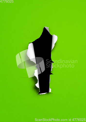 Image of Green torn paper with black hole