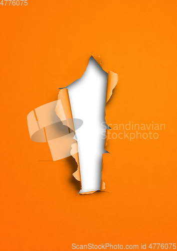 Image of Orange torn paper with hole