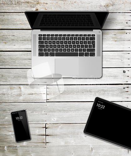 Image of Laptop, tablet and phone set mockup on a wooden background. 3D r