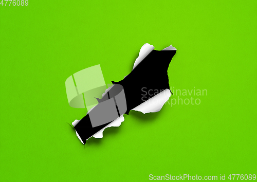 Image of Green torn paper with black hole