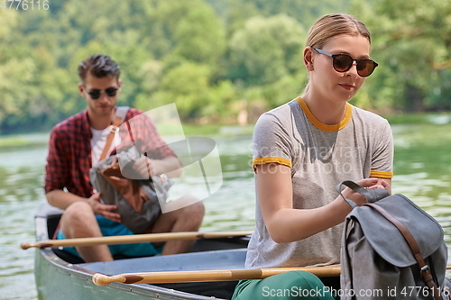 Image of friends are canoeing in a wild river
