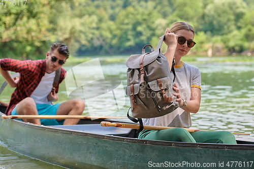 Image of friends are canoeing in a wild river