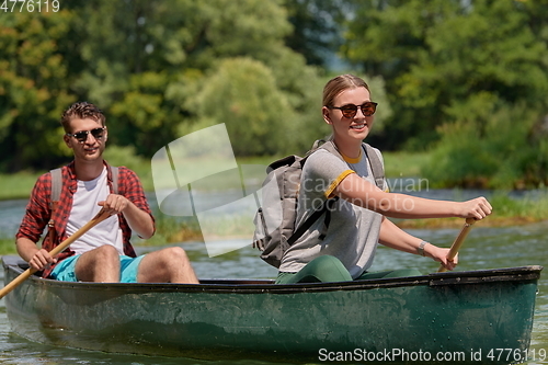 Image of friends are canoeing in a wild river