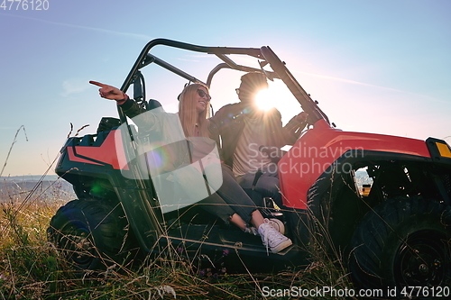 Image of couple enjoying beautiful sunny day while driving a off road buggy