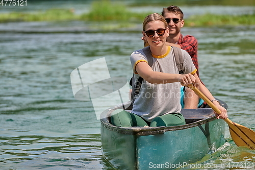 Image of friends are canoeing in a wild river