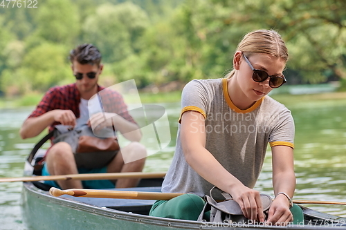 Image of friends are canoeing in a wild river