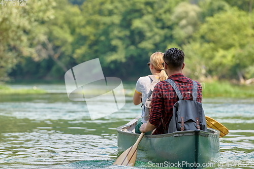 Image of friends are canoeing in a wild river