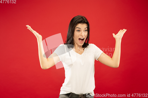 Image of Caucasian young woman\'s half-length portrait on red background