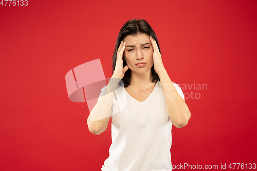 Image of Caucasian young woman\'s half-length portrait on red background